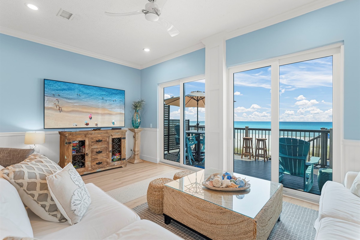 Step in: the first-floor living room opens to sweeping Gulf views. Plush seating + an 86-inch 4K TV + surround sound = movie nights with waves crashing outside.