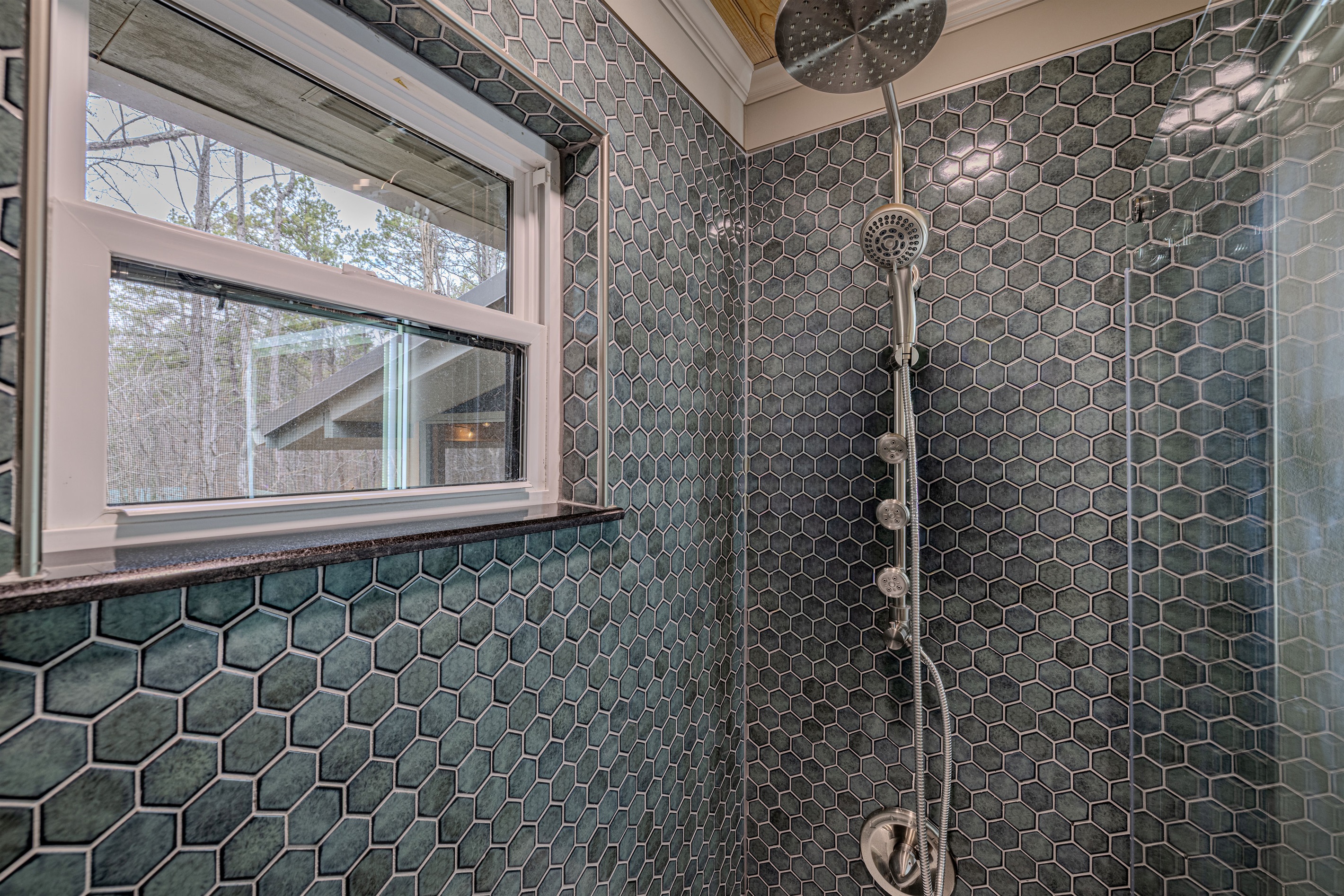 Wash away the day in a spa-like sanctuary. The deep teal tones and geometric patterns create a refreshing, modern atmosphere for your mountain morning routine.