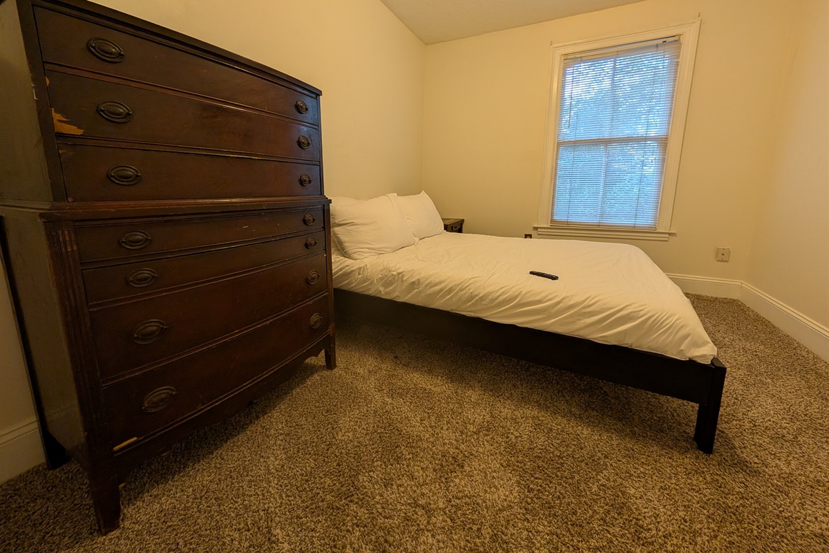 Guest bedroom upstairs with queen bed and smart tv