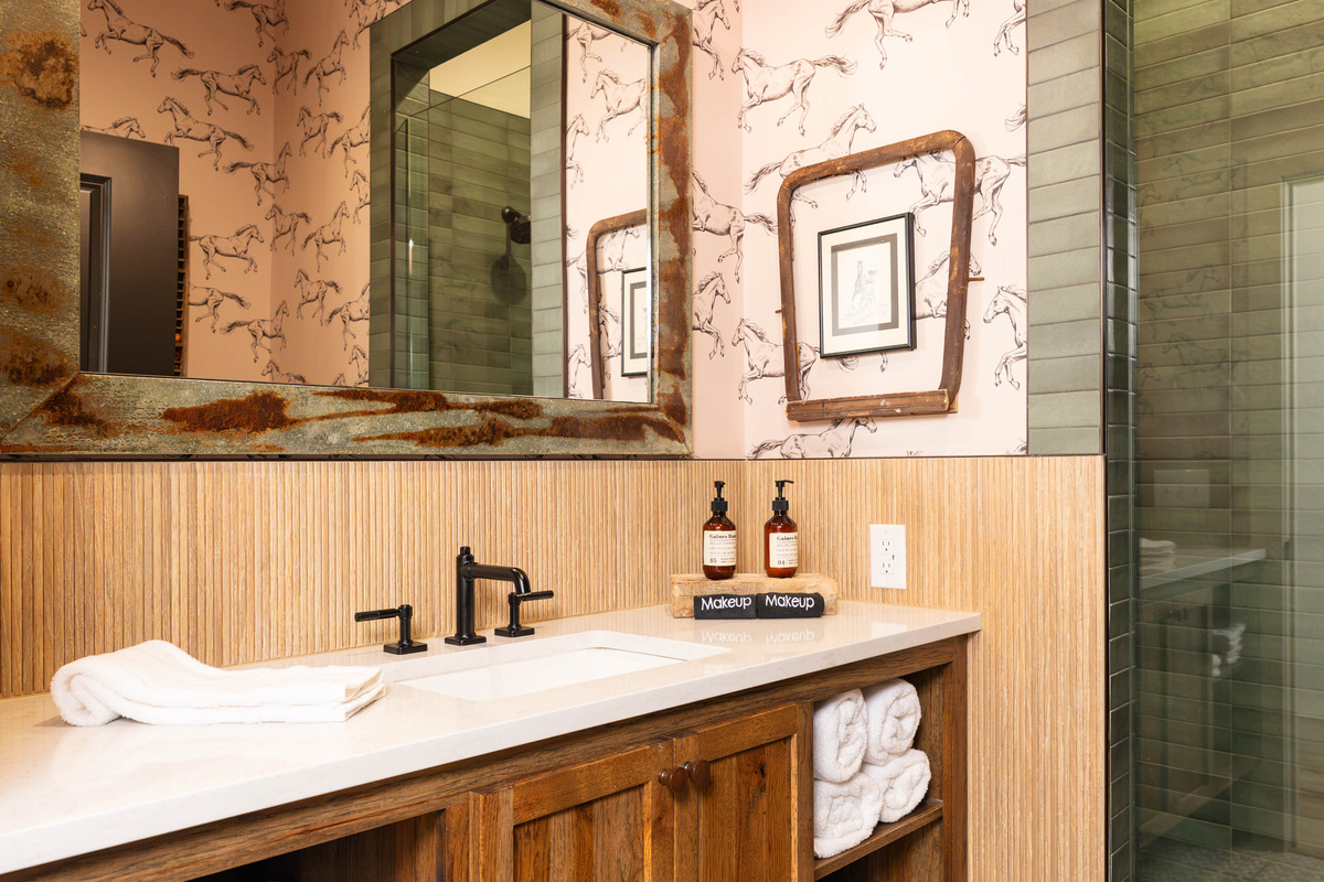Private en-suite bathroom at Rancher's Rest — designer vanity, walk-in tile shower, and modern Western finishes at Gaines Ranch on the Square.