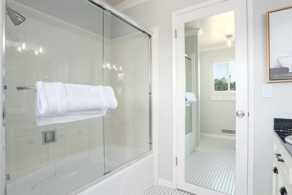 Convenient hallway bathroom featuring a shower over a tub.