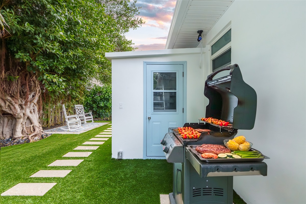 Fire up the grill! Enjoy the perfect backyard BBQ setup surrounded by lush Florida greenery.