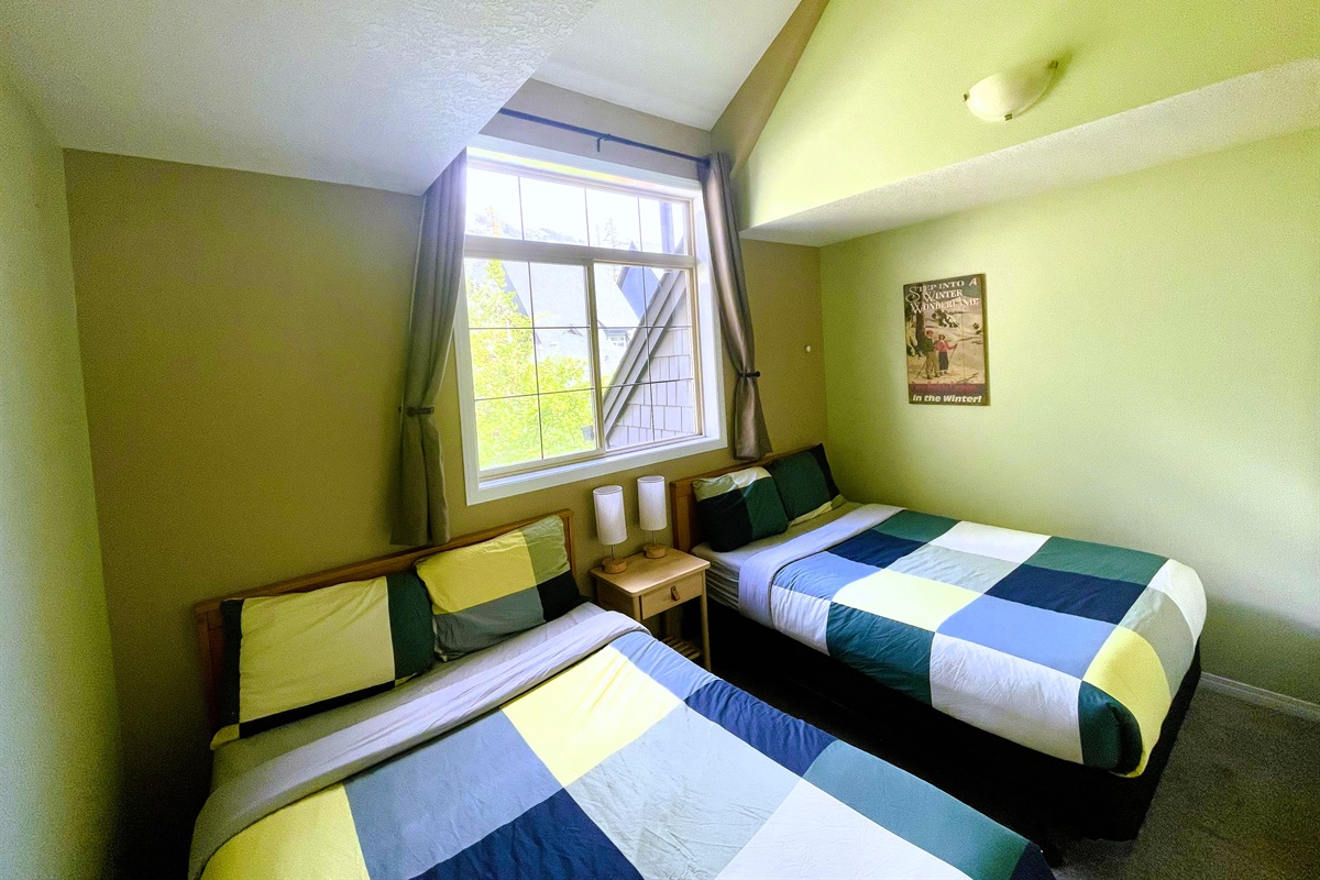 2nd bedroom, with vaulted ceilings, two double beds.  Adjacent bathroom in hallway.  Located on 2nd floor.