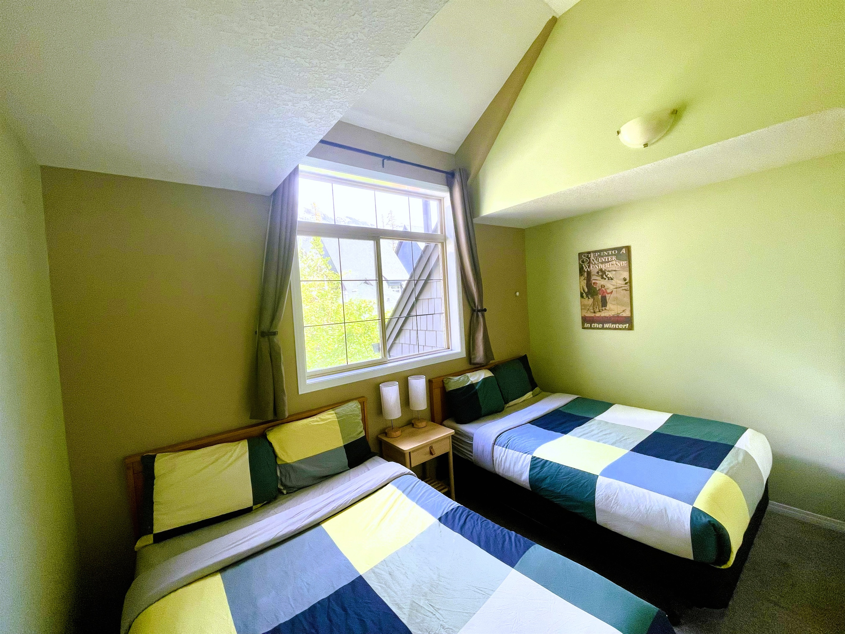 2nd bedroom, with vaulted ceilings, two double beds.  Adjacent bathroom in hallway.  Located on 2nd floor.