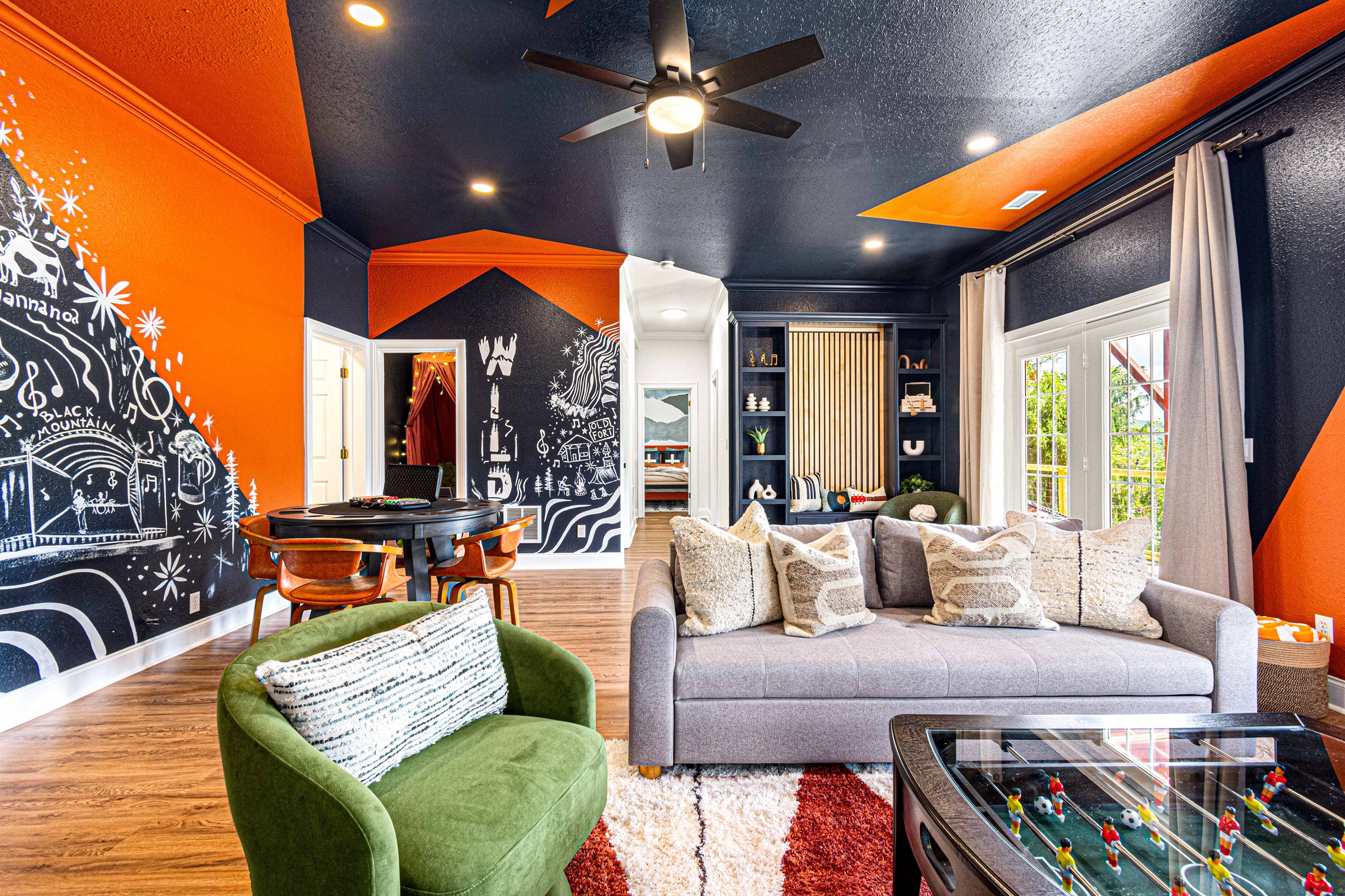 Bold colors and playful murals bring energy to this vibrant living space, complete with game tables, cozy seating, and a stylish reading nook. Perfect for gatherings or a night of fun.