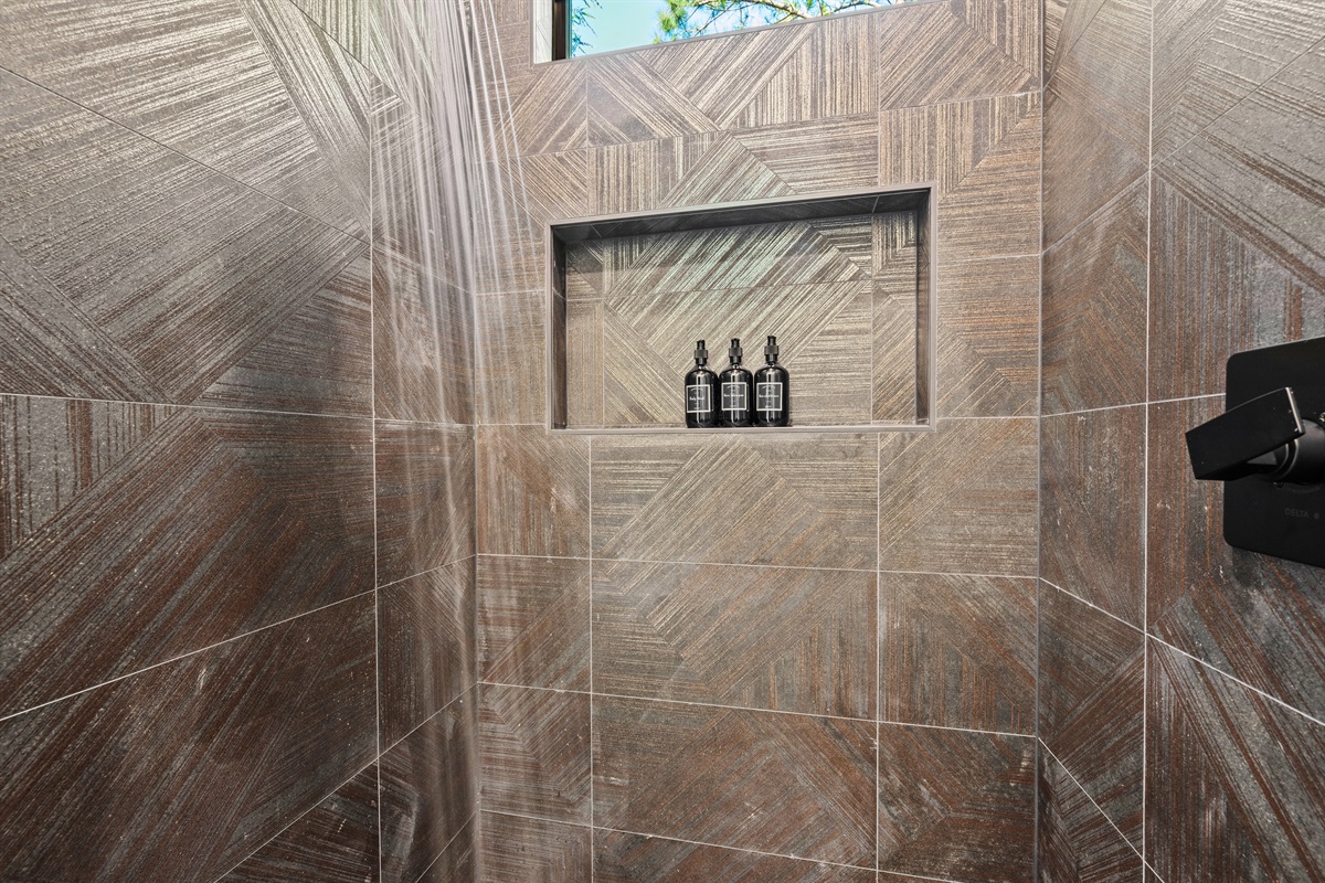 Wrapped in rich tilework and warm tones, the walk-in shower adds a luxurious touch while still feeling comfortable and inviting.
