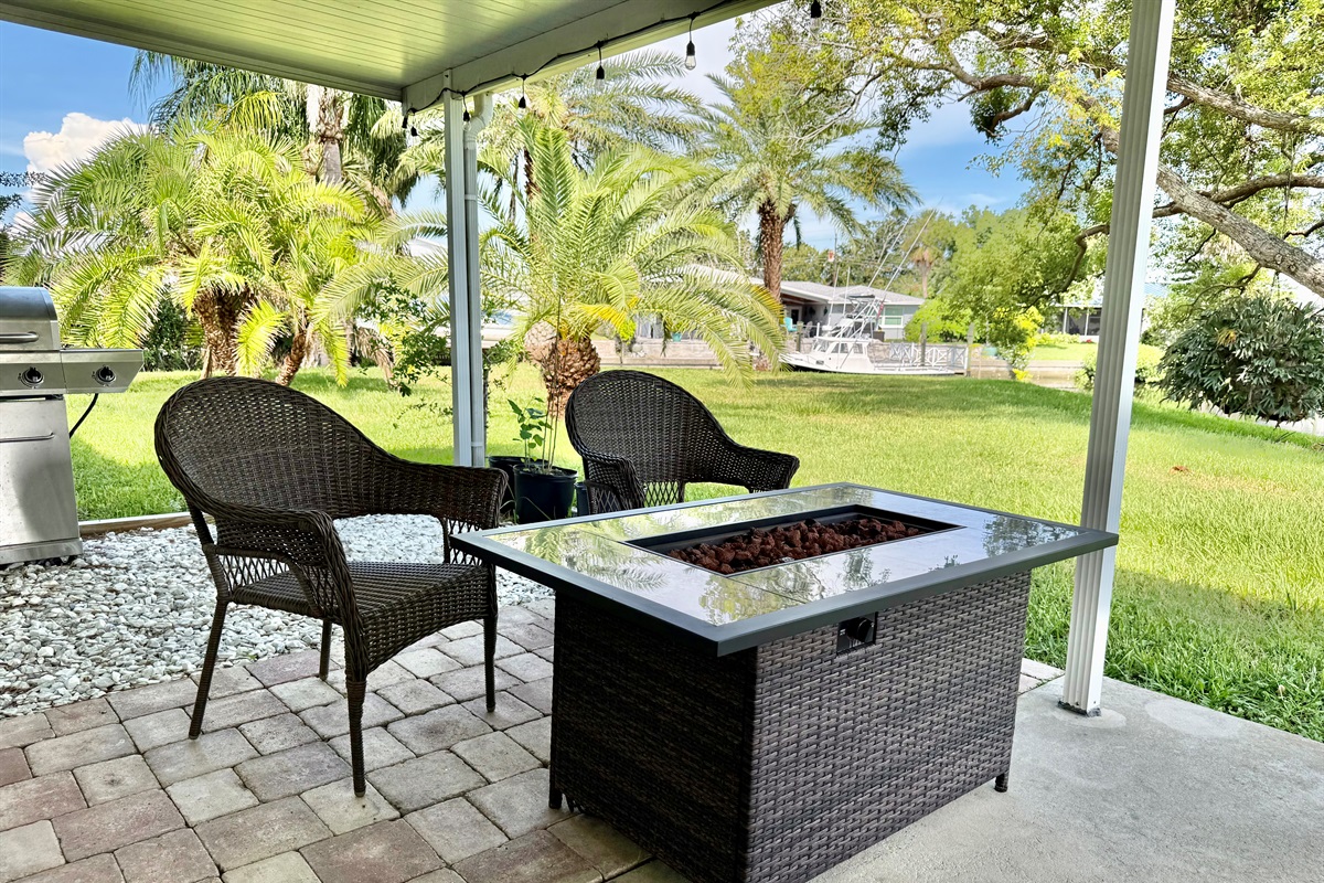 Step outside to your own tropical oasis—complete with a dining set, lounge chairs, a fire pit table, and palm-fringed views in every direction.