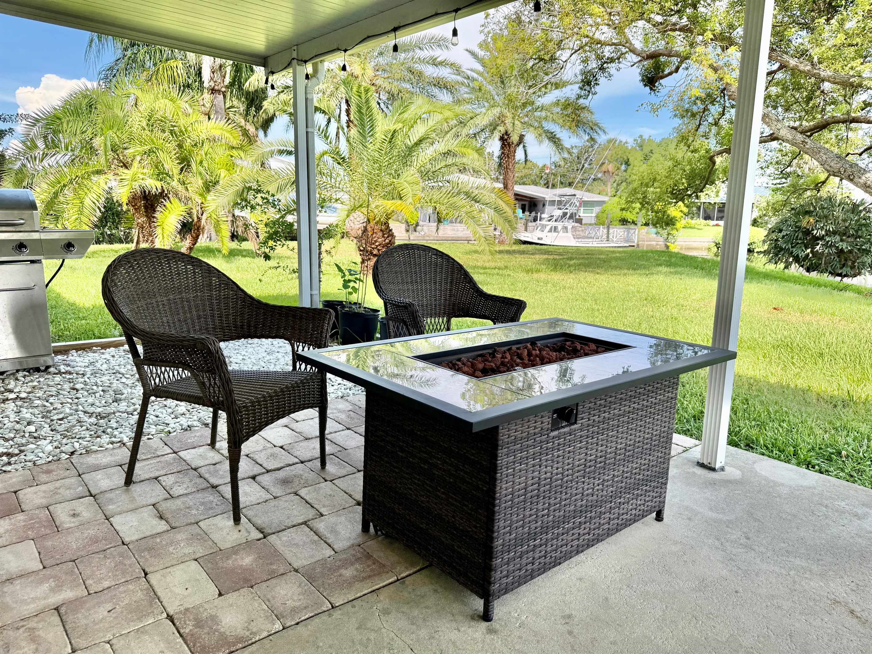 Step outside to your own tropical oasis—complete with a dining set, lounge chairs, a fire pit table, and palm-fringed views in every direction.