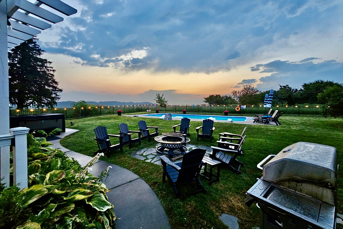 Enjoy peaceful early mornings, sunny afternoons, and memorable evenings in this private backyard featuring a pool, hot tub, fire pit, and sweeping country views.