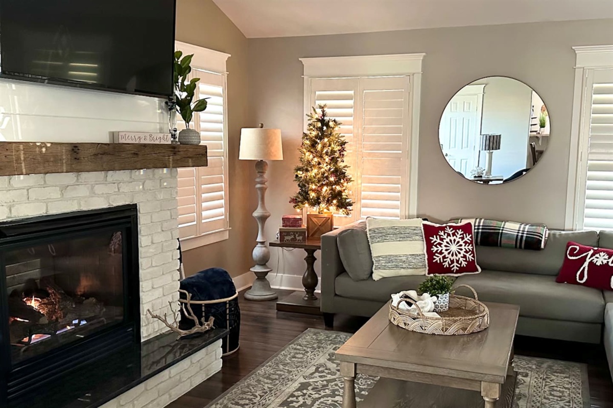 Decorated in November, the home features a cozy fireplace, festive snowflake pillows on the sofa, and a sparkling Christmas tree, creating the perfect atmosphere for a relaxing seasonal stay.