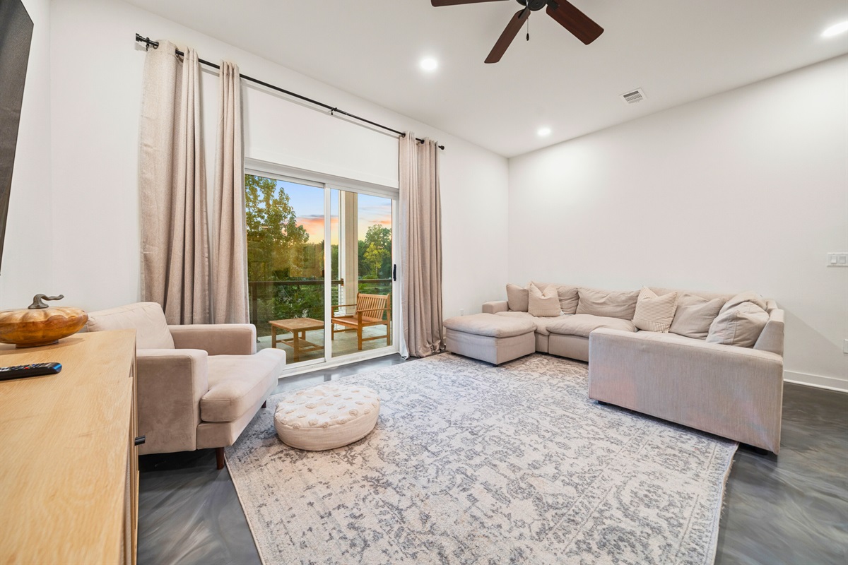 Living area with sectional sofa and direct patio access.