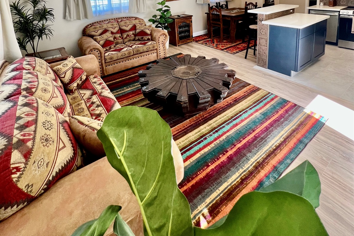 Soak up the natural light in this airy, open-plan space, featuring a unique, rustic Lazy Susan coffee table at the center of the living area.