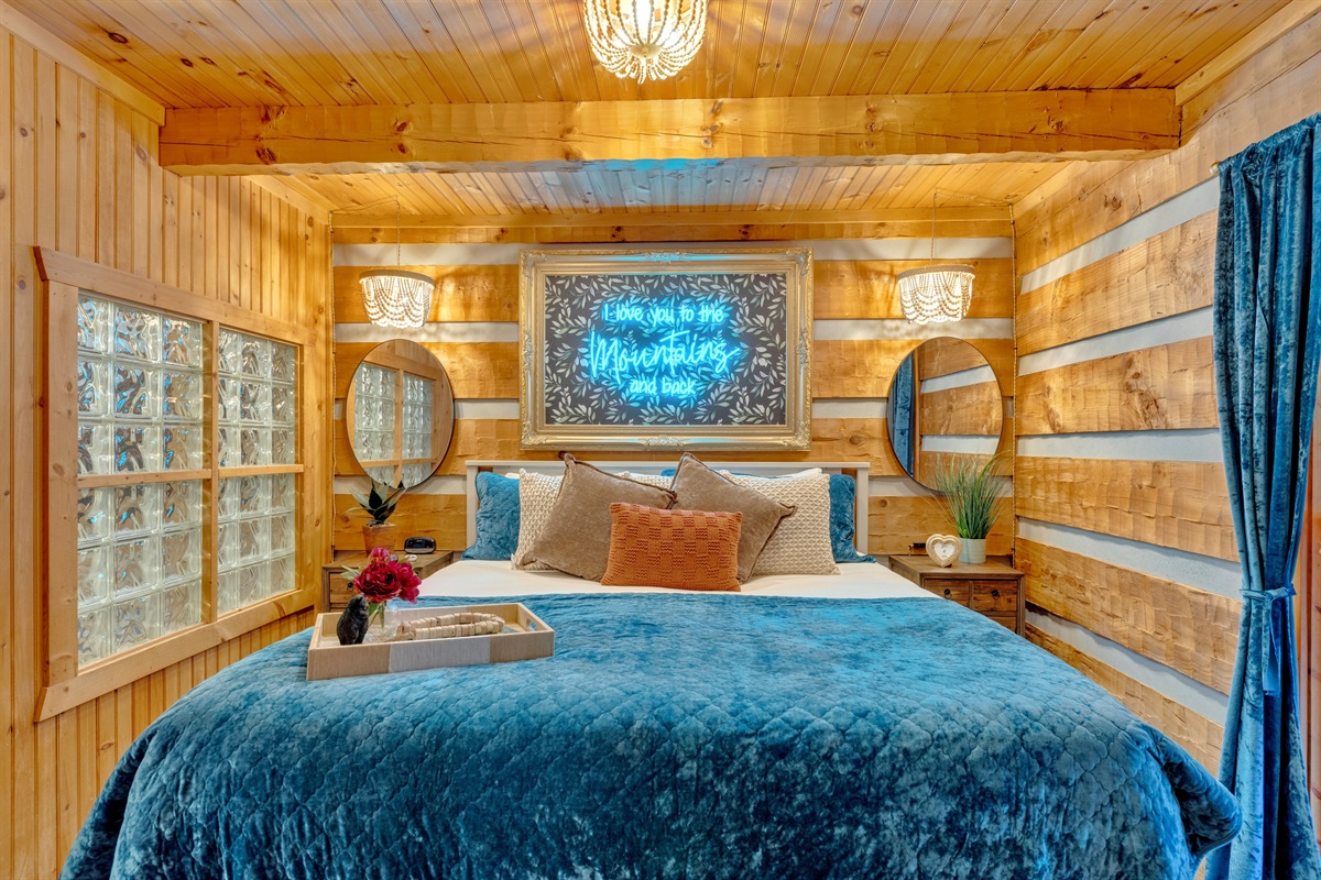 Rustic-chic bedroom with log walls, luxe bedding, and a romantic mountain vibe — designed for restful nights in the Smokies