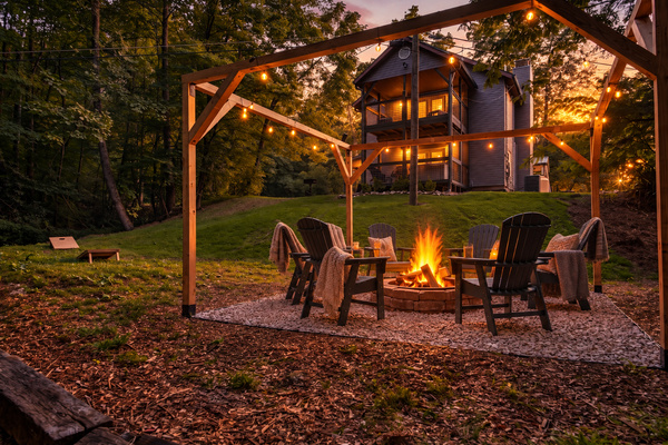 Fire pit at twilight with the house behind it. Evening ambiance at your Sevierville cabin rental.