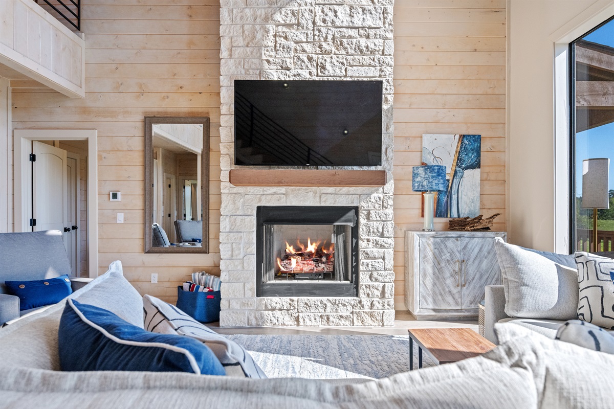 Cozy living area with stone fireplace and modern décor.