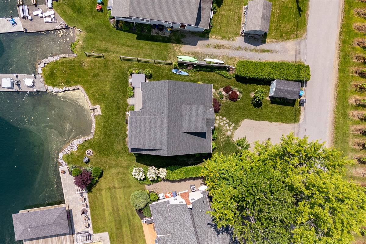 Stunning aerial view of a serene Finger Lakes waterfront retreat, complete with private dock, lush greenery, and charming lakefront homes—perfect for peaceful getaways and water adventures