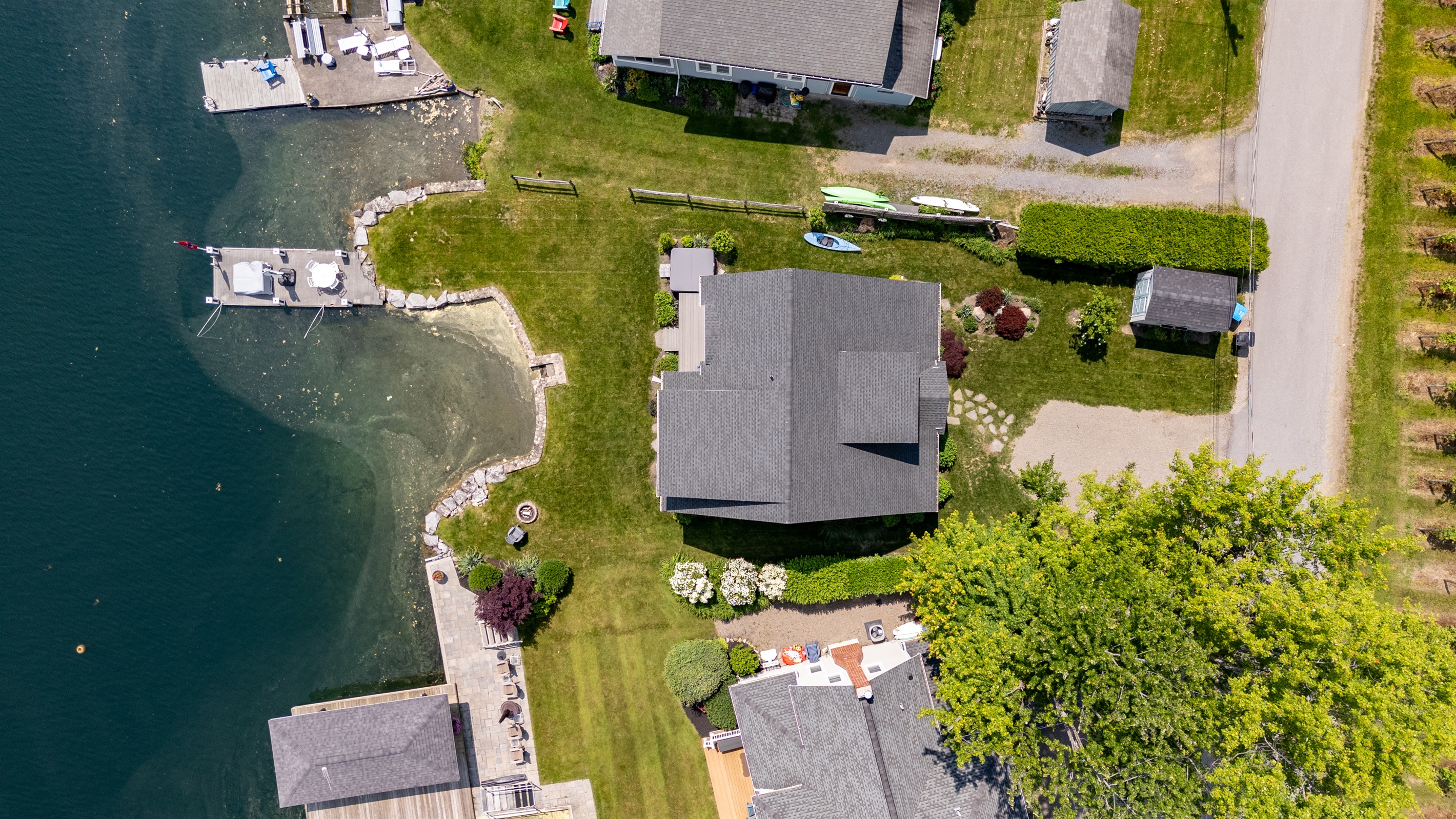 Stunning aerial view of a serene Finger Lakes waterfront retreat, complete with private dock, lush greenery, and charming lakefront homes—perfect for peaceful getaways and water adventures