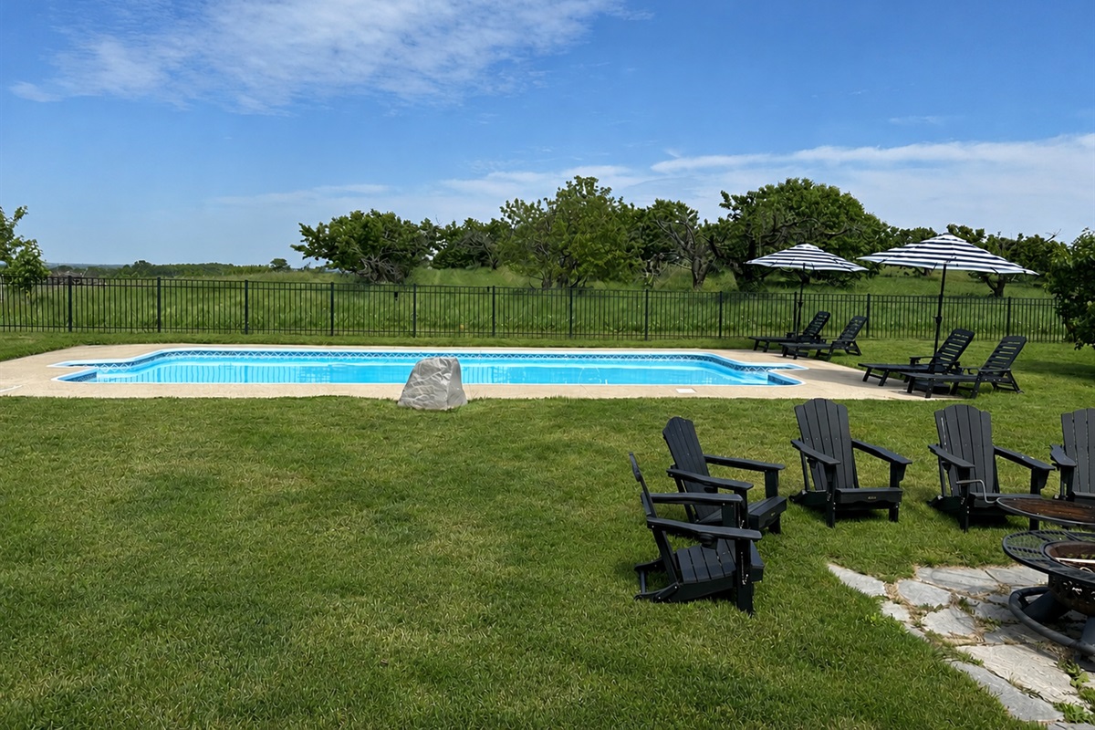 Your private pool oasis awaits! Lounge under striped umbrellas, cool off in the sparkling pool, gather around the fire pit, and soak in peaceful orchard views. The perfect backdrop for family vacations, friend getaways, and summer memories.