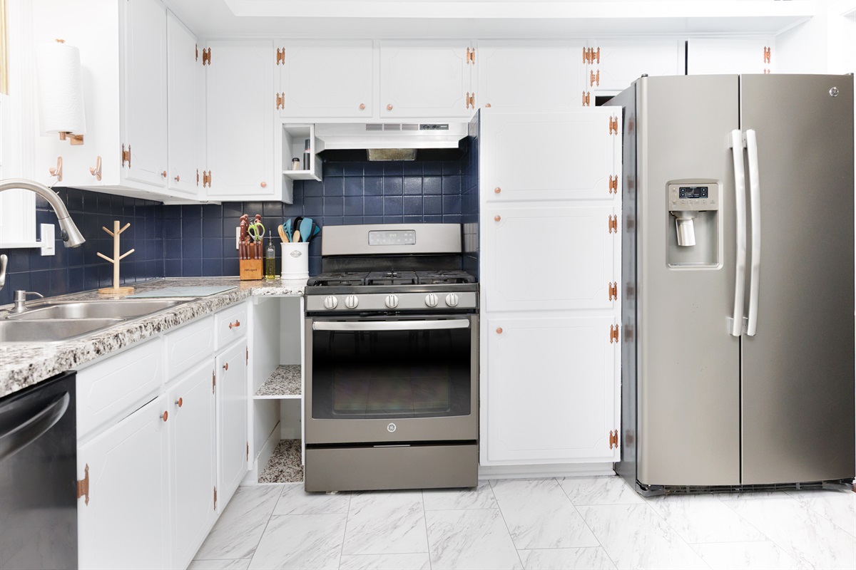 Modern kitchen appliances including refrigerator, stove, and dishwasher for a convenient stay.