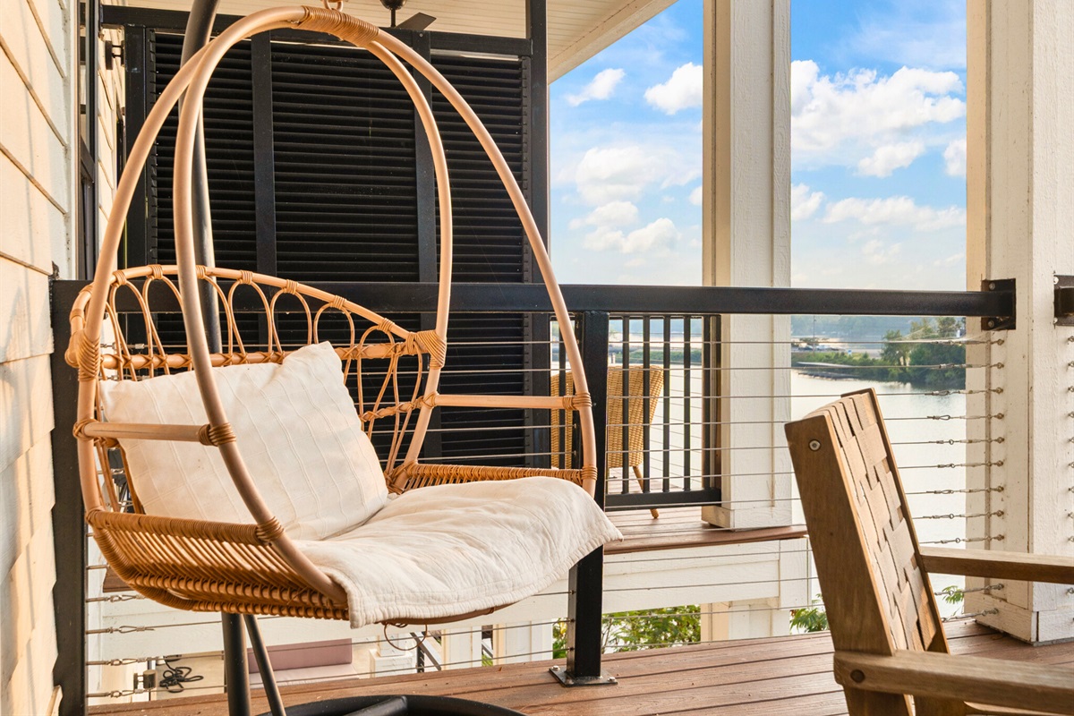 Stylish hanging chairs invite you to unwind and enjoy the gentle lake breeze on the private balcony.