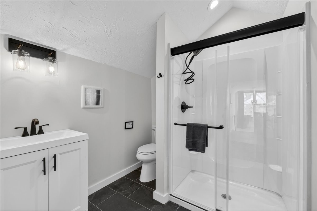 Fully equipped full second-floor bathroom featuring contemporary amenities, including a sleek shower and ample storage. 