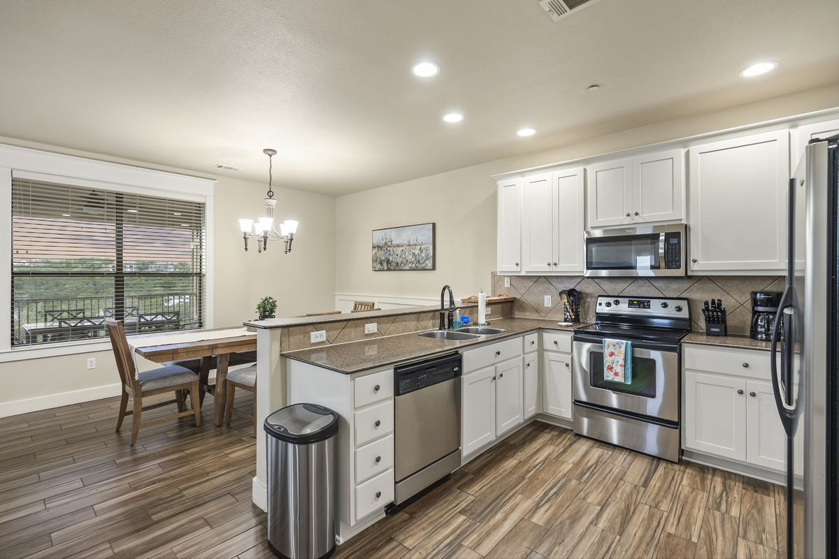 Full kitchen with granite countertops, breakfast bar, and plenty of space for preparing meals. The open layout connects the kitchen with the dining and living areas.
