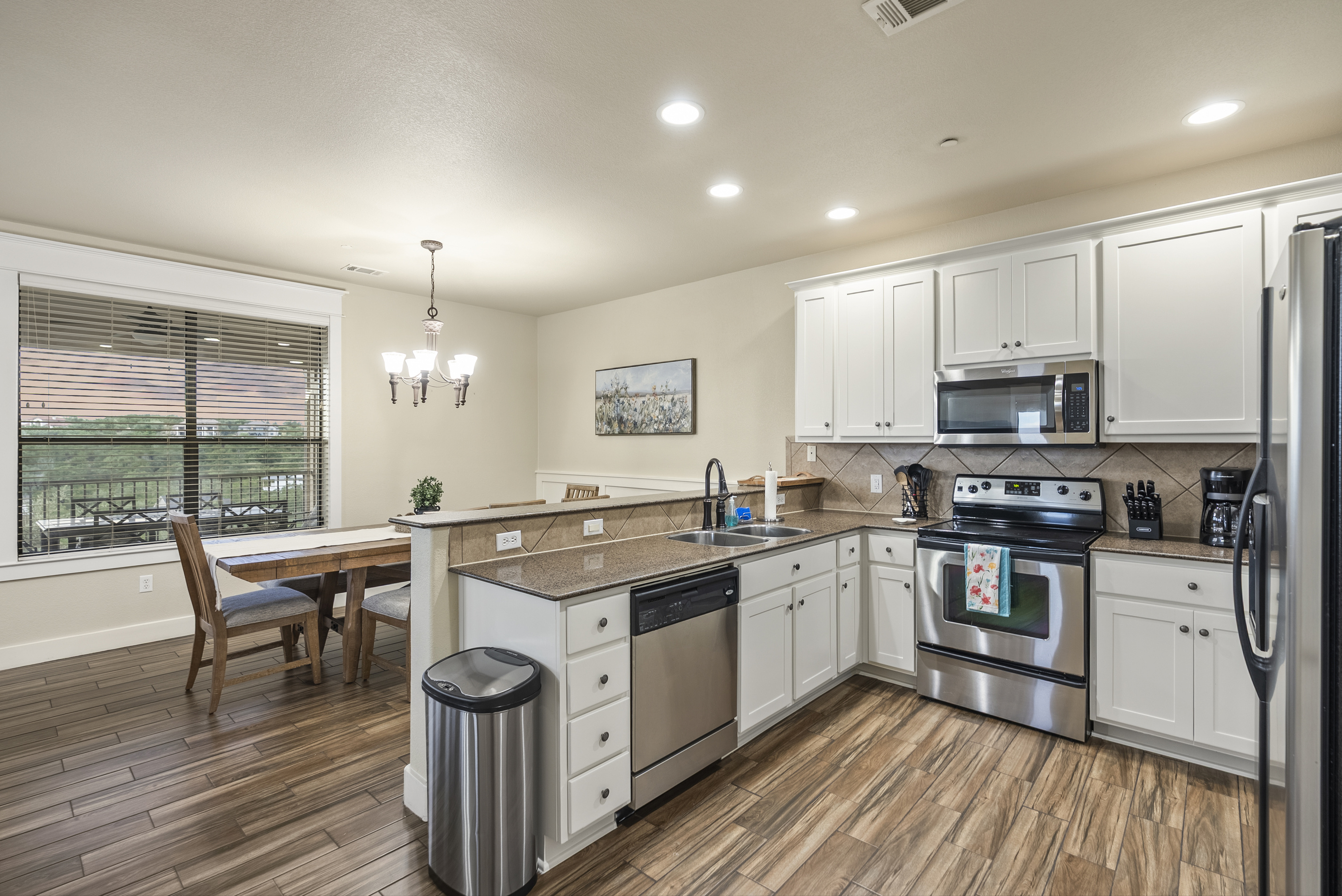 Full kitchen with granite countertops, breakfast bar, and plenty of space for preparing meals. The open layout connects the kitchen with the dining and living areas.