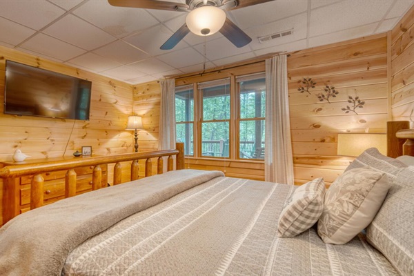 Downstairs bedroom with king bed, smart tv, and view of the creek