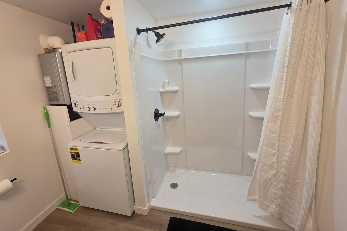 Bathroom with large shower and washer and dryer.