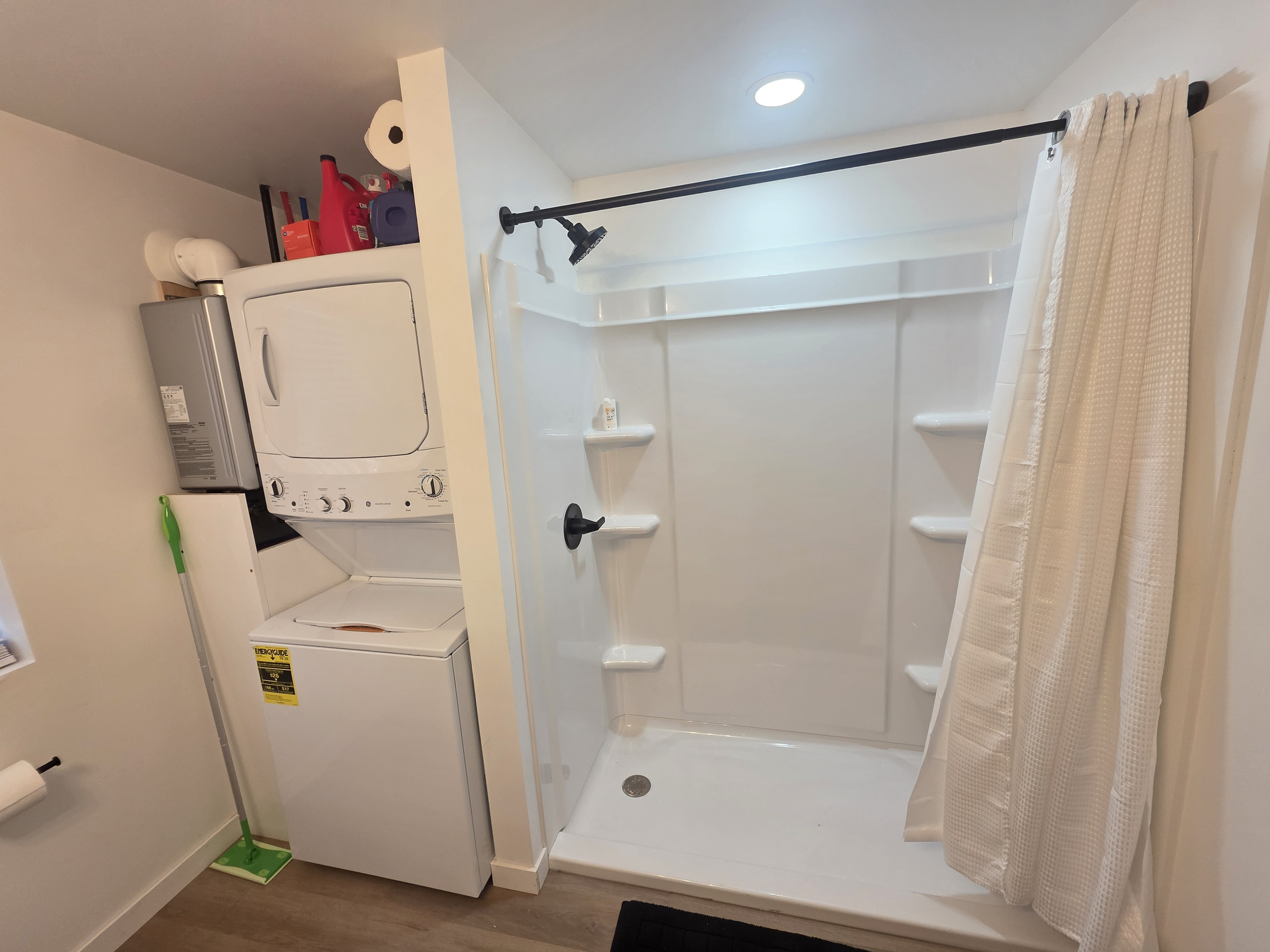 Bathroom with large shower and washer and dryer.