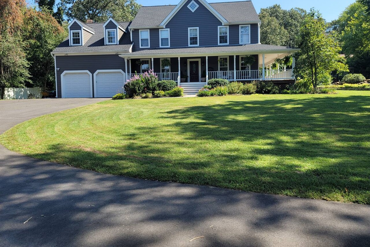 House front has large driveway, large grass yard, with a nice view from the large wrap around porch. 