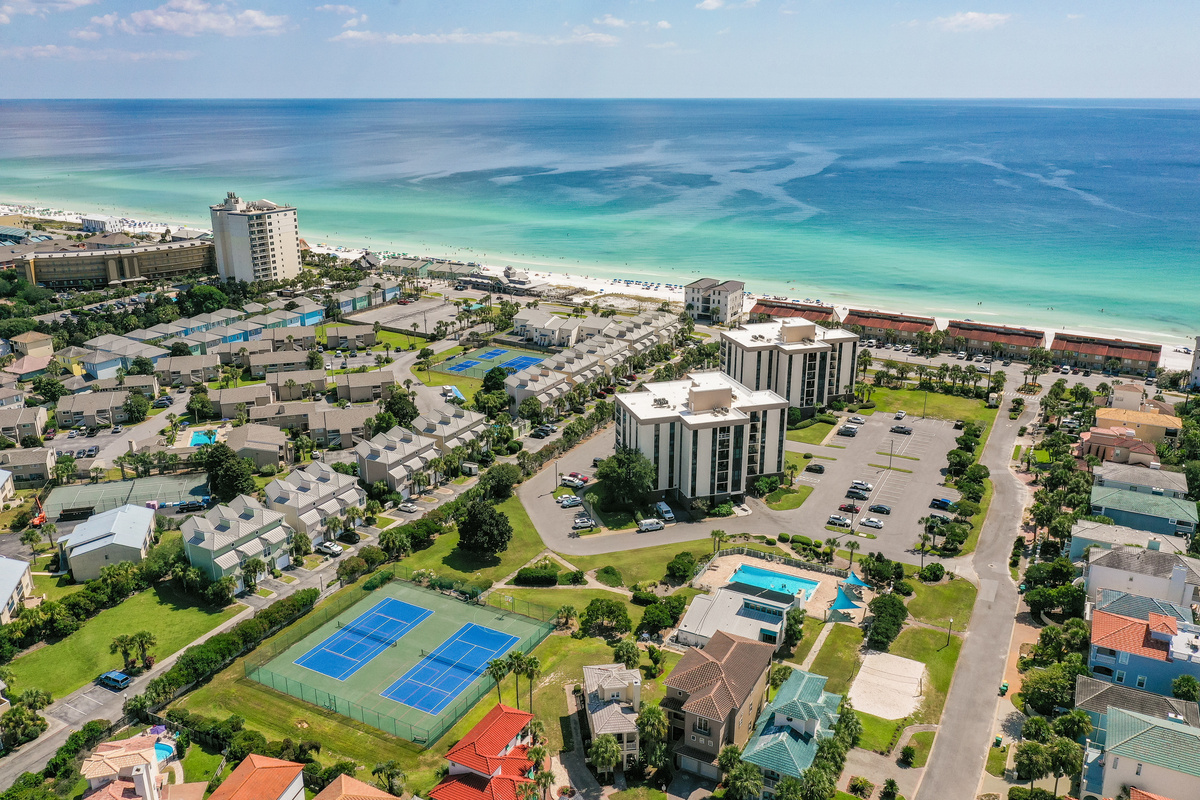 Aerial view of Oceanic View inside The Enclave community—featuring nearby tennis courts, community amenities, and beautiful private beach access just a short distance away. 🌊🏖️🎾