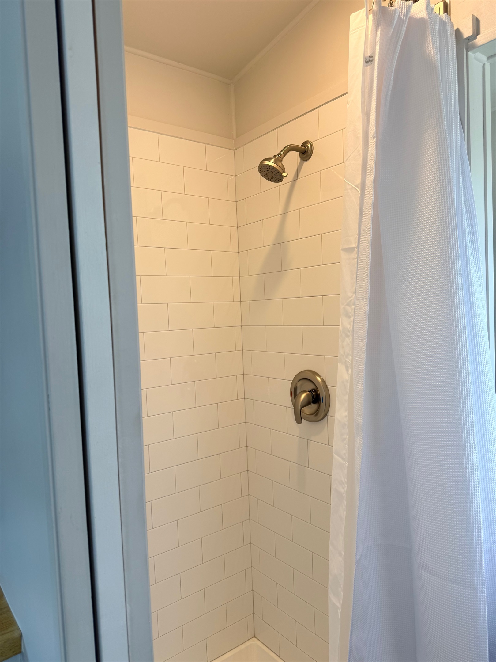 Nice size bathroom with shower, sink and residential toilet