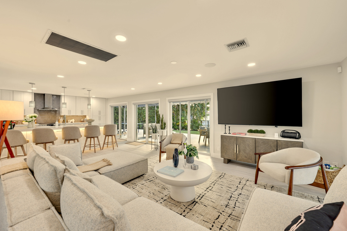 Settle into the spacious living room with a large sectional, big-screen TV, and sliding doors that keep the patio and pool close by.