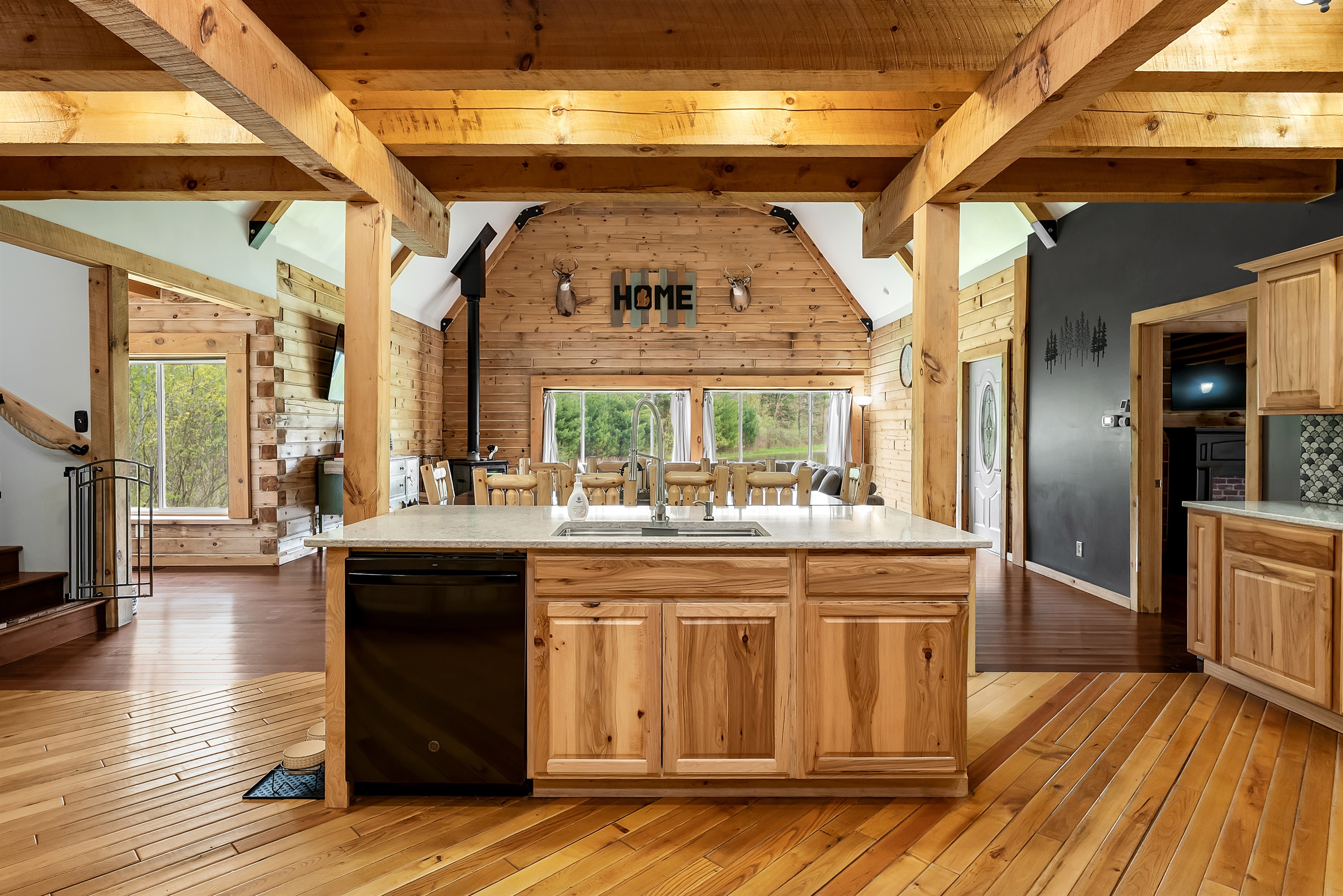 View of kitchen sink island with dishwasher, looking into the living room.