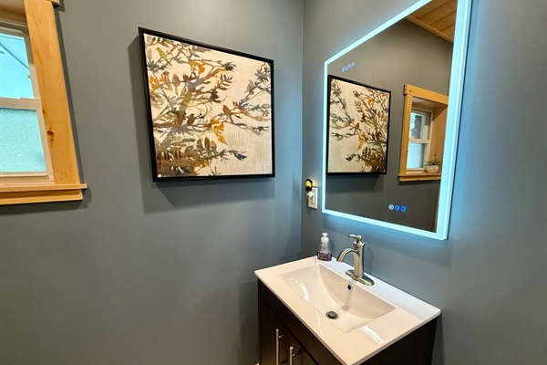Renovated bathroom with a spacious tile shower, bench, glass enclosure, and modern vanity. Bright, functional, and comfortable.