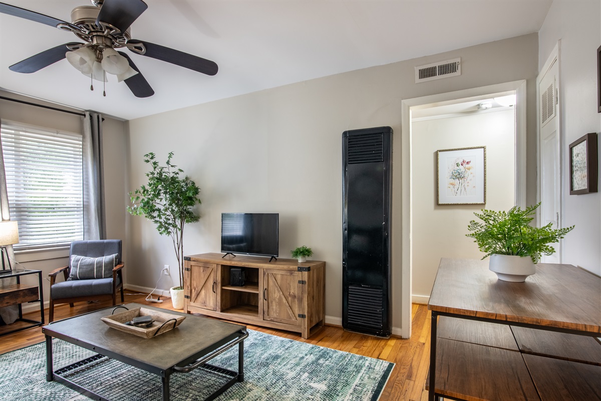 Cozy living space with smart TV, comfy seating, and natural light—ideal for relaxing or working remotely.