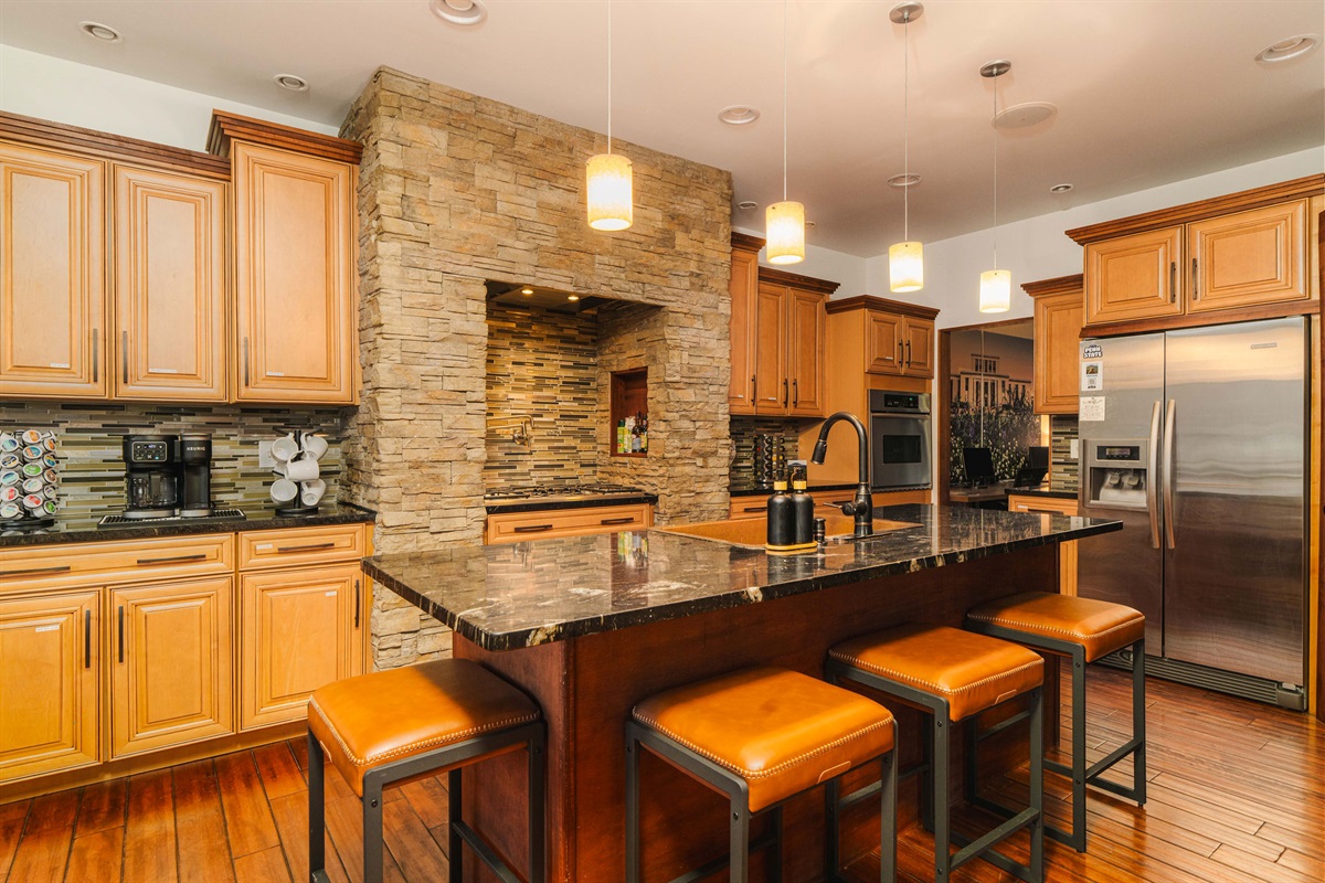 Fully equipped kitchen with island seating, modern appliances, and ample prep space for large groups.