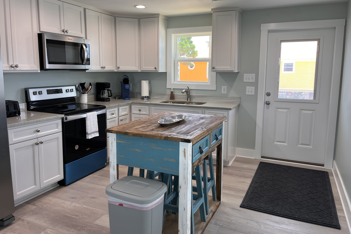 Fully equipped kitchen featuring modern appliances and comfortable dining seating for four.
