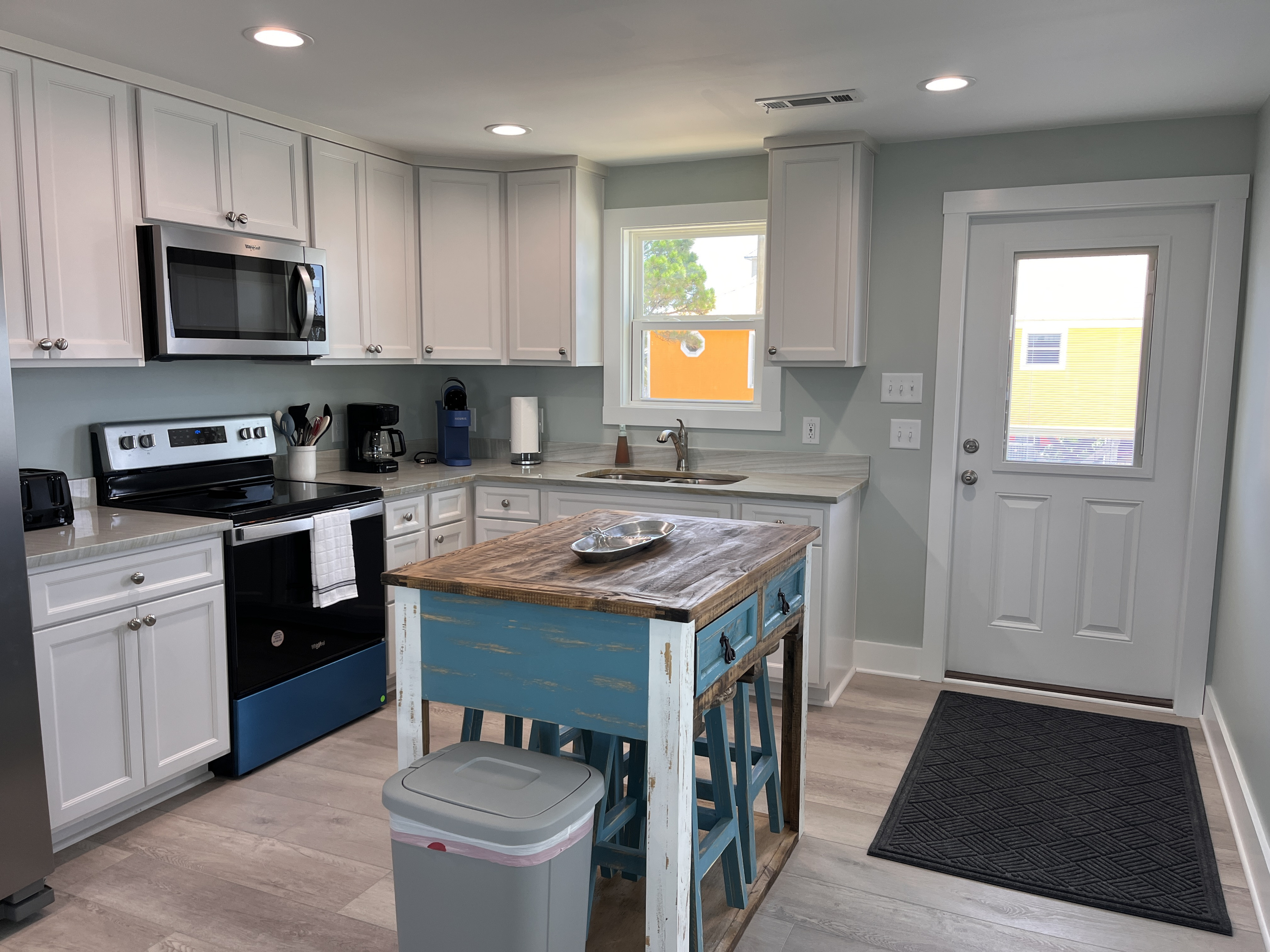 Fully equipped kitchen featuring modern appliances and comfortable dining seating for four.