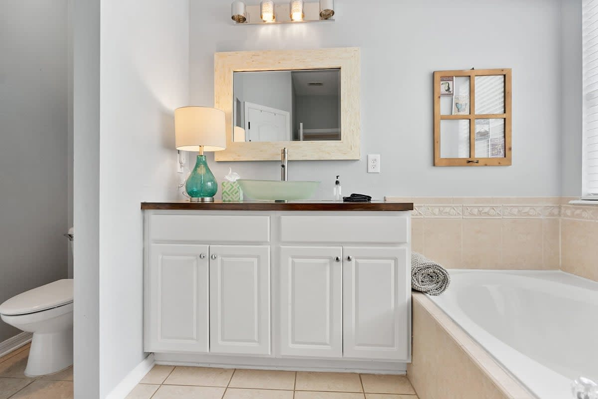 The first-floor primary bathroom, with a corner jetted tub and a generous vanity. After a day between the pool and the Atlantic, twenty minutes in that tub is the most persuasive argument for an early night.