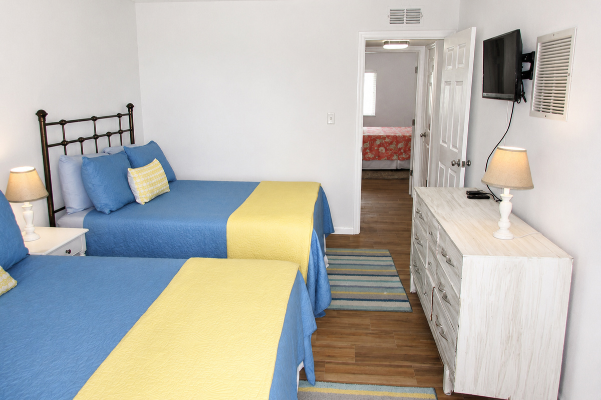 Cheerful twin bedroom with blue and yellow accents, cozy decor, and bright inviting style.