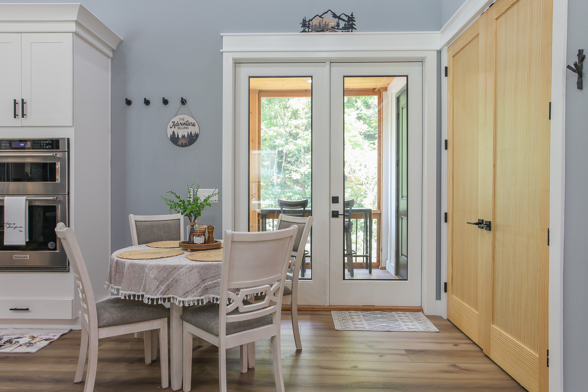 Enjoy a leisurely meal at Robbin’s Nest on Snowbird Creek, with glass doors beside the dining table leading to the covered porch.