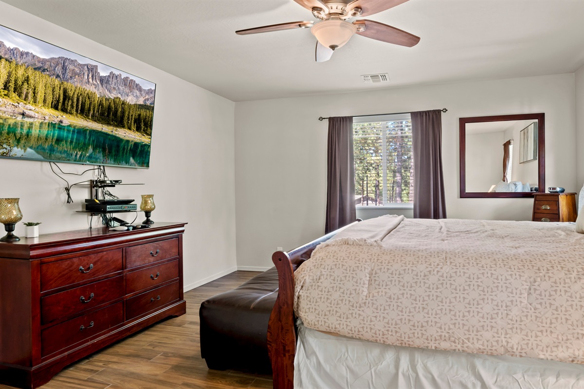 Enjoy restful nights in this beautiful master bedroom, featuring a plush king bed, a TV for entertainment, and a dresser to make you feel at home.