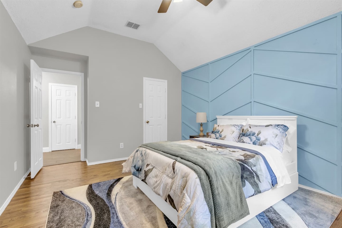 Clean and spacious guest bedroom offering a queen bed, room-darkening blinds, ceiling fan, fresh linens, and climate comfort for a great night’s sleep.