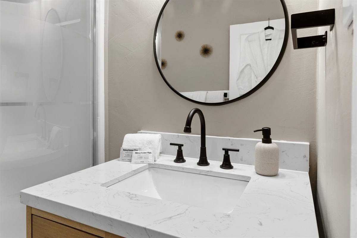 Composite marble-top vanity with matte black fixtures. Soaps, Linens and make-up wipes provided.