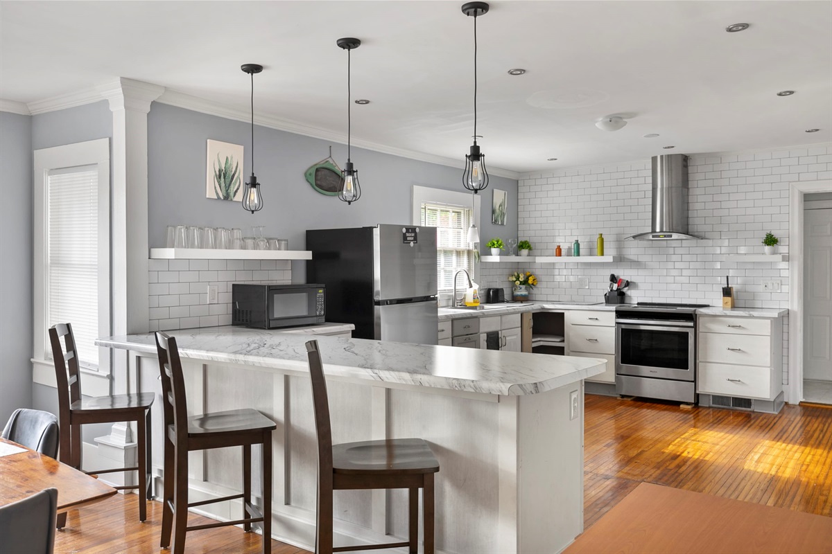 A bright kitchen with sleek finishes and three bar seats—perfect for casual meals or morning coffee