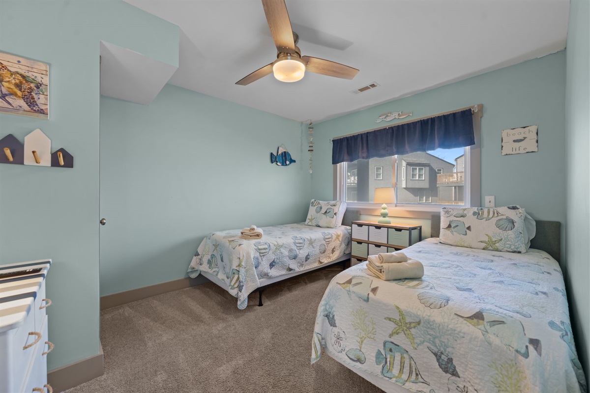 Fun, coastal-themed Kid's bedroom with two twin beds and a cozy layout&mdash;perfect for kids or extra guests