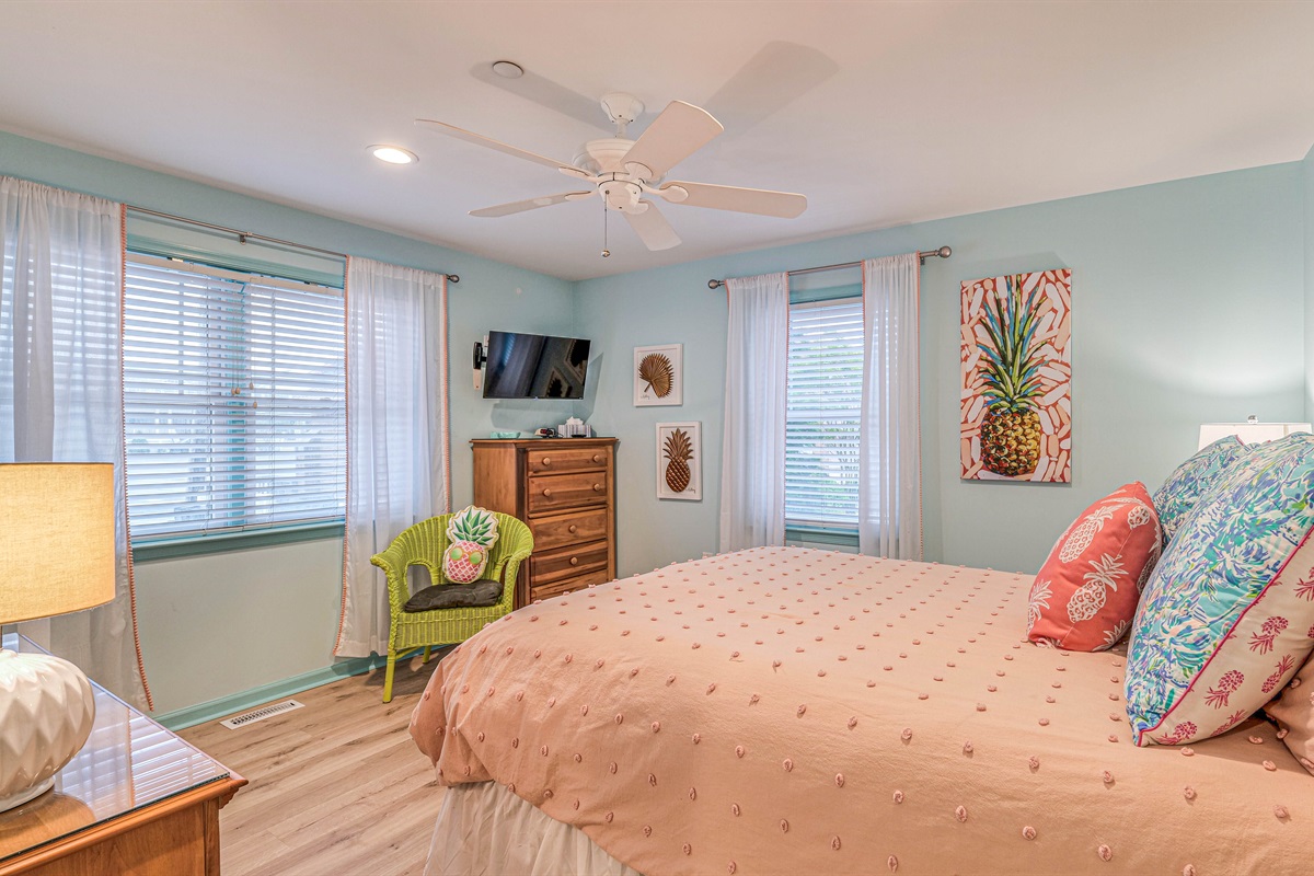 Queen sized bed with dresser and TV