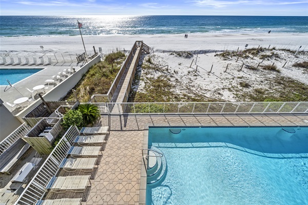 Balcony view of outdoor pool and beach boardwalk 